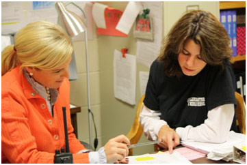 Two school employees discussing a document